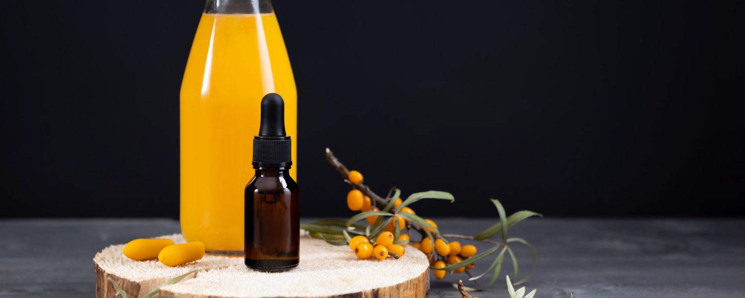 sea buckthorn berry products - oil, juice, rectal candles on a wooden background